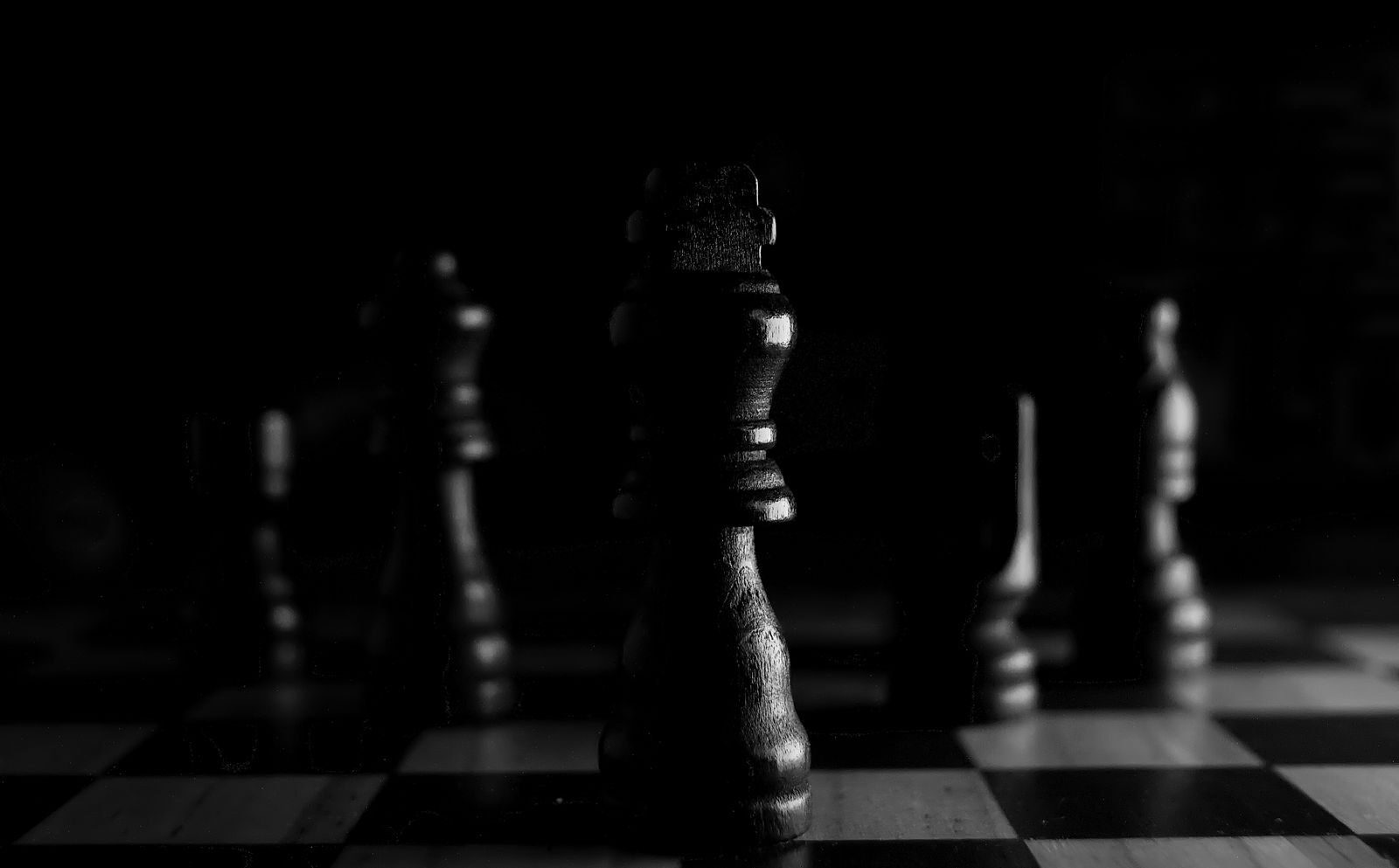Strategic close-up of chess pieces on a board, highlighting the queen in black and white.
