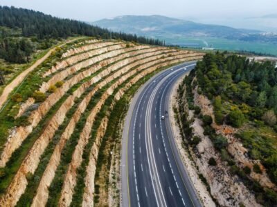 Stunning aerial view of a highway winding through terraced hills and lush greenery.