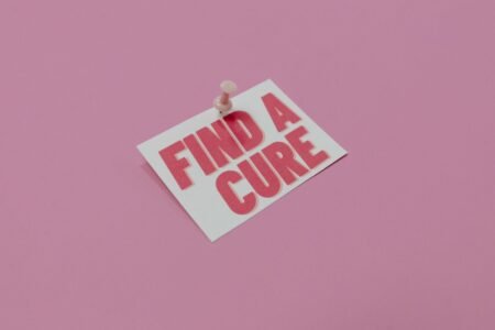 A pink note pinned with message 'Find a Cure', symbolizing cancer awareness.