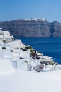 Picturesque Santorini white houses with Aegean Sea view under clear blue sky.