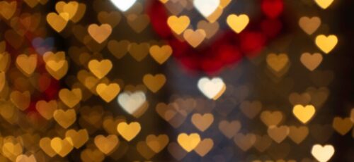 Warm and romantic heart-shaped bokeh lights creating a festive atmosphere. Perfect for Valentine's Day themes.