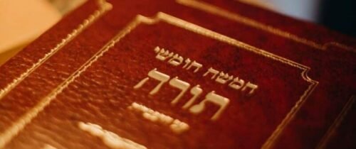 A close-up view of a Torah book with Hebrew text, symbolizing Jewish tradition and spirituality.