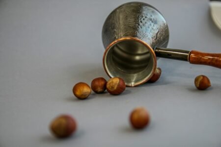 stainless steel cup beside brown round medication pill