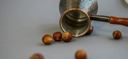 stainless steel cup beside brown round medication pill
