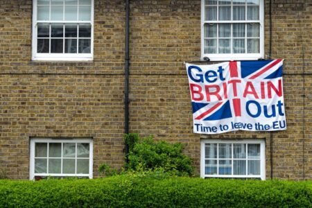 Brick home displaying Brexit protest sign with Union Jack design.