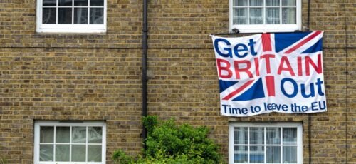 Brick home displaying Brexit protest sign with Union Jack design.