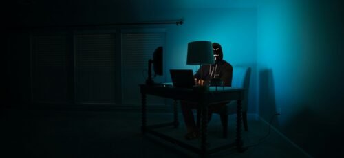 man siting facing laptop