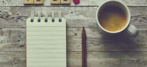 a cup of coffee next to a notepad with the words to do on it