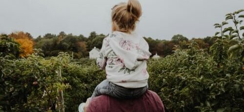 photo of girl riding on person shoulder