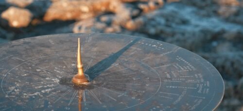 A sundial casting a shadow on a textured surface